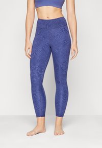 Leggings a vita alta, aderenti, in un materiale blu scuro testurizzato, con un design a motivo e una fascia elastica in vita per il comfort.