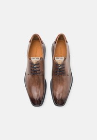 Scarpe da uomo eleganti in pelle marrone lucida, con lacci neri, punta quadrata e soletta interna con marchio, su sfondo bianco.