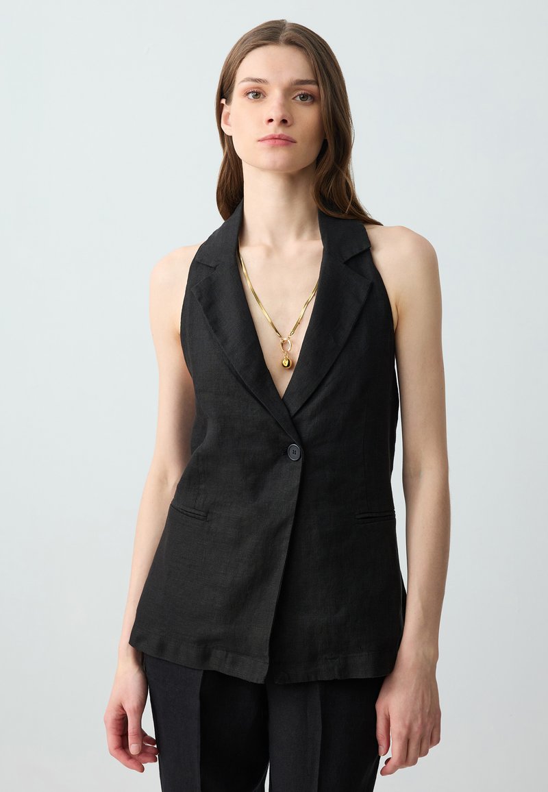Blazer senza maniche in lino nero con scollatura a V profonda, revers, chiusura con un bottone e due taschelaterali.