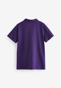 Polo shirt violet à manches courtes, avec un col et un tissu texturé. Le dos est uni et solide, sans détails supplémentaires.