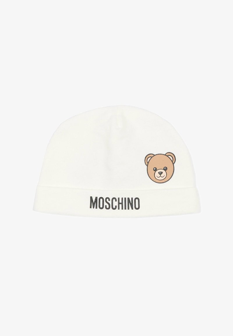 Gorro blanco de tela suave, con un gráfico de oso y el logo "MOSCHINO" en negro en el puño. Diseño sencillo.