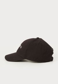 Sort bomuldsbaseballcap med buet skygge, justerbar rem bagpå og hvid broderet tekst på forsiden. Enkel design og mat overflade.