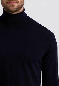 Marineblauer Rollkragenpullover aus weichem, feinem Strickstoff, mit taillierter Silhouette und geripptem Kragen für zusätzliche Textur.