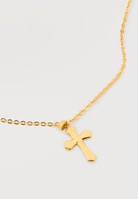 Χρυσό κολιέ αλυσίδα με γυαλιστερό σταυρό ως μενταγιόν που έχει φαρδιά άκρα, σε λευκό φόντο.