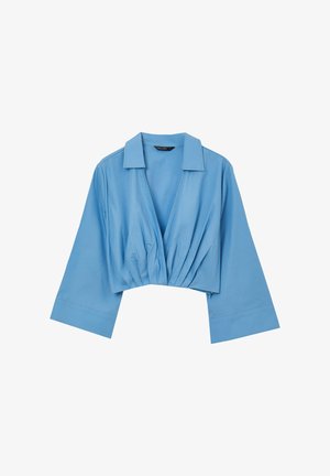 Camicetta azzurrino corta con colletto, caratterizzata da una scollatura a V e dettagli arricciati sul davanti. Realizzata in tessuto morbido con maniche ampie.