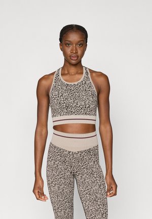 Ensemble de sport à imprimé animal, comprenant un soutien-gorge de sport beige ajusté avec un bandeau côtelé et un legging taille haute assorti.