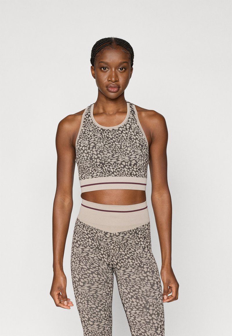 Loomade prindiga treeningkomplekt, mis koosneb sobivast beežist spordirinnahoidjast ribakujulise vööga ja vastavatest kõrge vöökoha retuusidest.