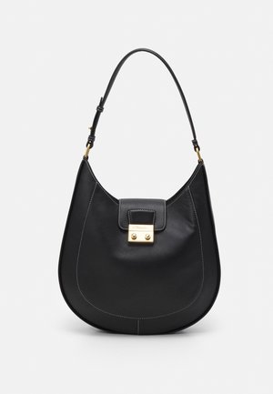 Borsa a mano in pelle nera con una forma curvata, dettagli in metallo dorato e cuciture bianche. Presenta una chiusura a patta e un'unica tracolla.