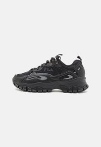 Baskets de sport noires avec panneaux en maille et en cuir, semelle en caoutchouc texturée et accents surélevés. Comprend des lacets et un logo de la marque.