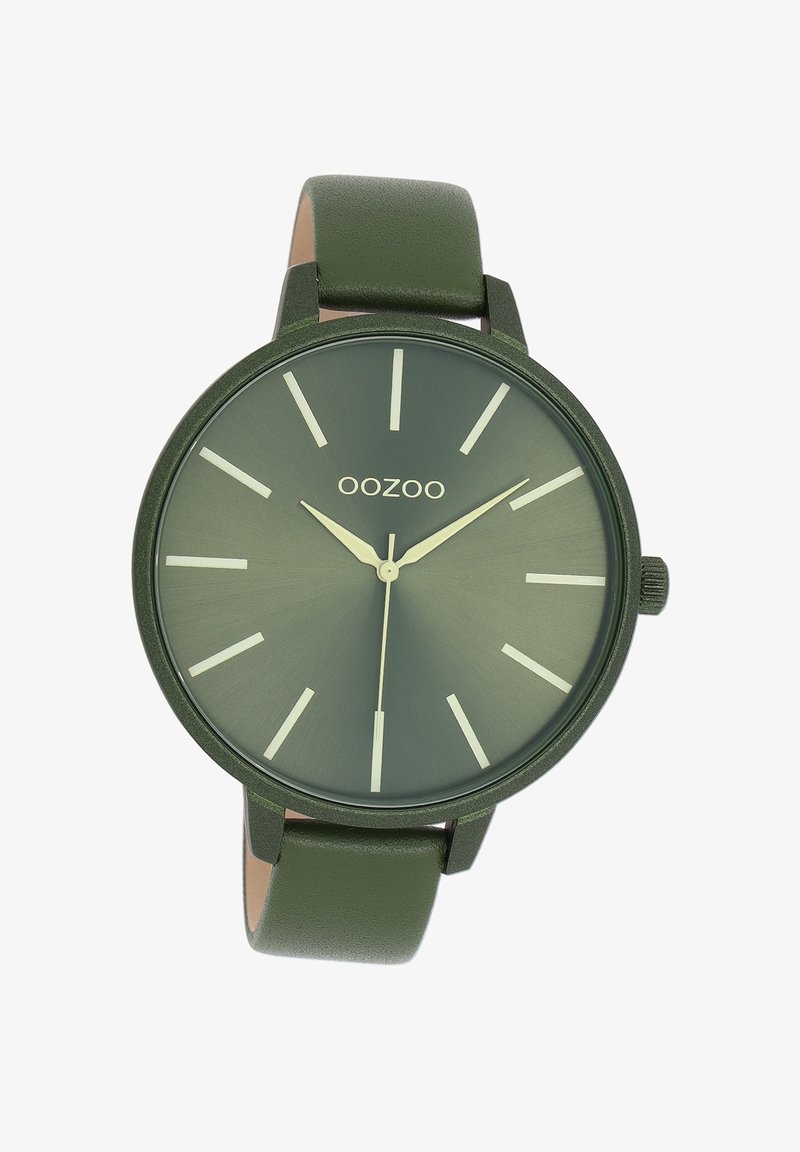 Montre verte avec une finition mate, au design minimaliste, dotée d'index horaires blancs contrastants et d'un bracelet en cuir vert lisse. Logo de la marque "OOZOO" affiché.