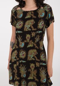 Robe noire à manches courtes ornée de motifs multicolores complexes d'animaux et de plantes, fabriquée en tissu doux avec une coupe décontractée.