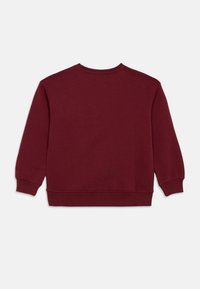 Sudadera burdeos de manga larga, cuello redondo, y puños y dobladillo de canalé. Fabricada con material suave y textura lisa.