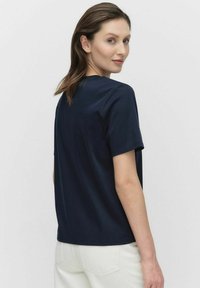 Marinblå t-shirt med kort ärm i avslappnad passform, tillverkad av bomull, med rund hals och rena sömdetaljer.