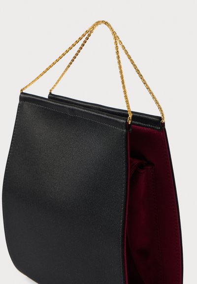 Musta käsilaukku, jossa on sileä pinta, viininpunainen sisävuori, kultainen ketjurepun kahva ja jämäkkä muotoilu. Avoin yläosa minimalistisella tyylillä.