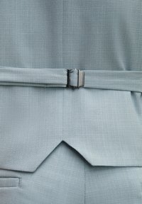 Helles blaues strukturiertes Gewebe mit einem Gürtel und einer silbernen Schnalle, das ein maßgeschneidertes Design mit einem spitzen Saumdetail zeigt.
