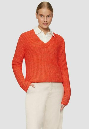 V-Ausschnitt, langärmeliger Pullover aus leuchtend orangefarbenem Strick mit lockerer Passform und gerippter Textur, kombiniert mit einem weißen Hemd mit Kragen darunter.