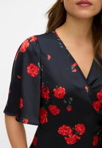 Robe noire à manches courtes et bouffantes. Présente un motif floral vibrant avec des roses rouges et des feuilles vertes, fabriquée dans un matériau lisse.