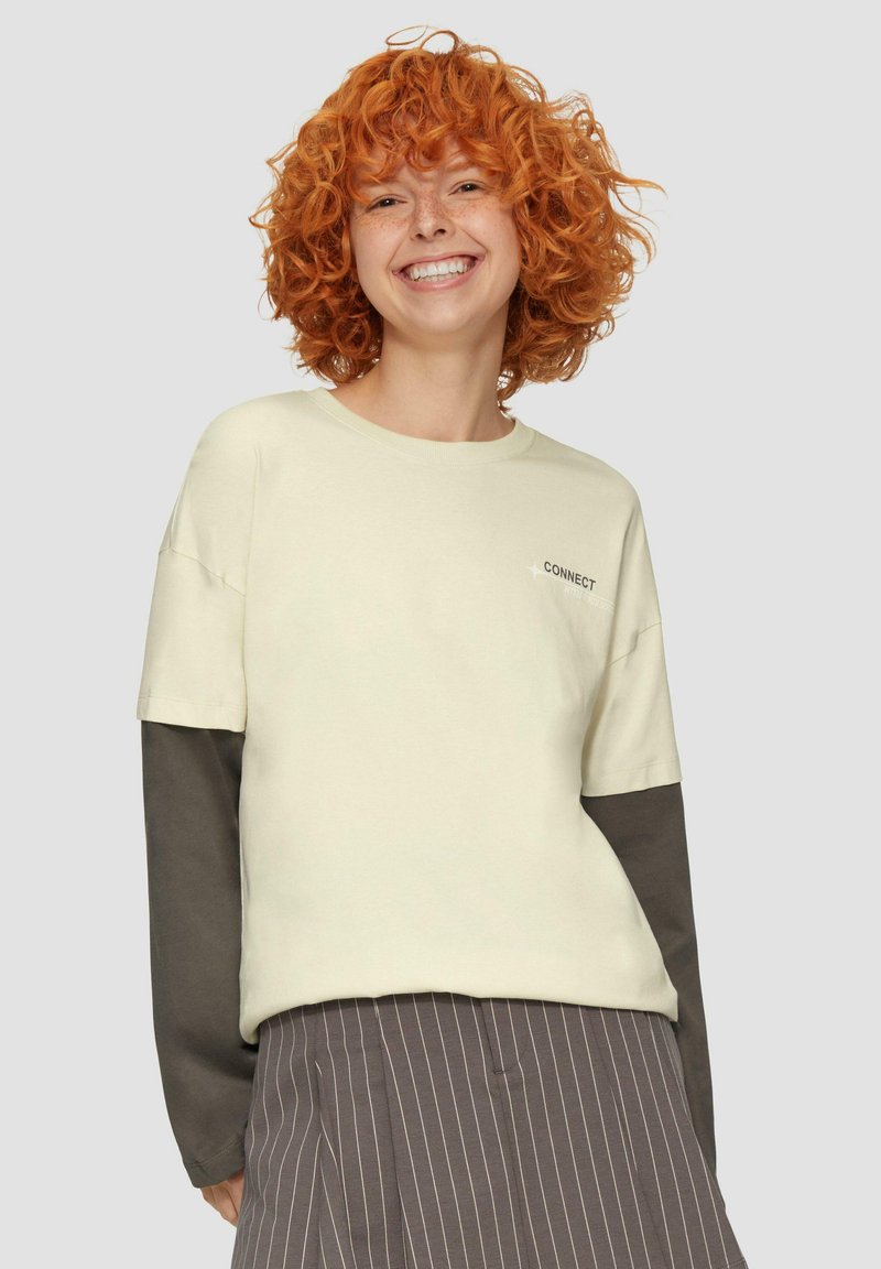 Helle Cremefarbenes Sweatshirt mit dunkelgrauen langen Ärmeln. Mit „CONNECT“-Text, Rundhalsausschnitt und lässiger Passform. Vertikal gestreifter Rock.