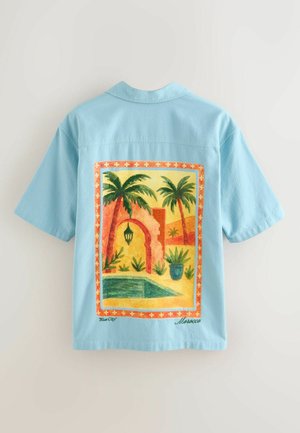 Jasnoniebieska koszula z krótkim rękawem z kolorową, marokańską grafiką palm, łuku, latarni, roślin i basenu na plecach.