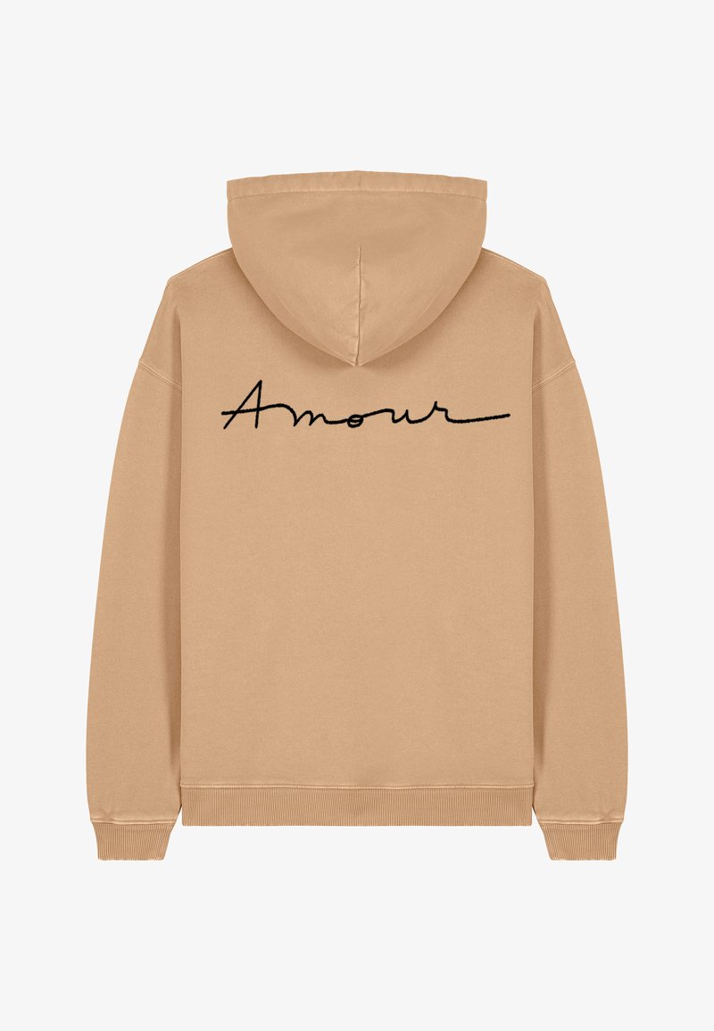 Sweat à capuche beige avec une capuche spacieuse et des poignets côtelés. Présente la mention "Amour" en cursif noir imprimée dans le dos. Texture douce.