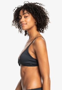 Black ribbed bikini top with thin straps and a triangular design. Fabric appears smooth with subtle texture. No visible hardware details.