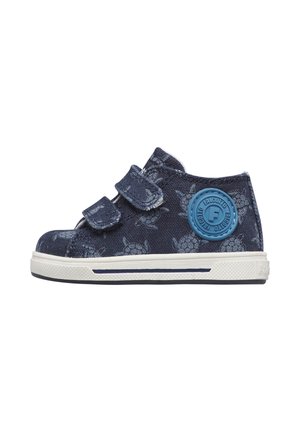 Scarpa da bambino blu scuro con motivo a tartaruga, due cinturini in Velcro, suola bianca e toppa con logo circolare blu sul lato.