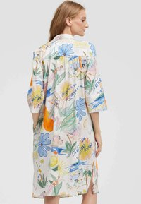 Leichtes, mehrfarbiges Kleid mit einem floralen und sommerlichen Print, kurzen Ärmeln und einer lockeren Passform sowie Seitentaschen.