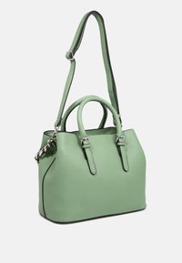 Zelená kožená kabelka s texturovaným povrchem, dvojitými uchy, nastavitelným popruhem a černým lemem. Obsahuje kovové detaily a má strukturovaný tvar.