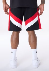 A fekete atlétikai rövidnadrágokon vastag piros és fehér átlós csíkok találhatók. Puha anyagból készülnek, laza szabásúak és oldalzsebekkel rendelkeznek.