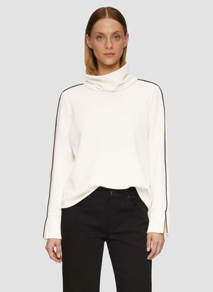 Sweatshirt blanc à col cheminée avec des manches longues, featuring des bandes latérales noires et des poignets cousus. Assorti avec un pantalon noir. Texture lisse.
