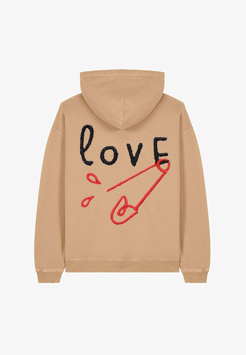 Hoodie beige avec un grand design brodé affichant le mot "amour" en noir et un motif de épingle de sûreté rouge. Texture douce et poignets ajustés.