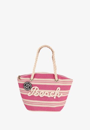 Sac fourre-tout rayé rose et beige avec une anse en corde, portant l'inscription "Plage" brodée en blanc. Fermeture éclair et étiquette de logo ronde attachée.
