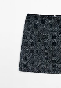 Mini-jupe texturée gris foncé avec une subtile étincelle et un ourlet droit sur fond blanc.