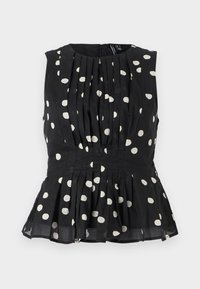 Svart ermeløs topp med hvite prikker, med plisserte detaljer og peplum-søm. Tøyet ser lett og strukturert ut. Bakre glidelås-lukking.