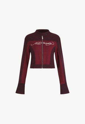 Women's cropped jacket in two-tone dark red with front zipper, stand collar, flared cuffs, and white script logo across the chest.