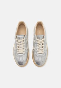 Sølvsneakers med glatt lærfinish, beige snørebånd og subtile hvite striper, med avrundet tå og teksturert gummisåle.