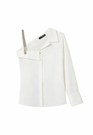 Blusa bianca asimmetrica con una manica lunga, spalla opposta scoperta con bretella di strass e apertura frontale con bottoni.