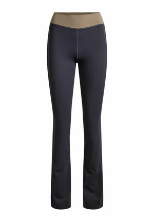 Pantalones deportivos negros de talle alto con cinturilla ancha beige, ajustados en los muslos y ligeramente acampanados en la parte inferior, sin logotipos visibles.