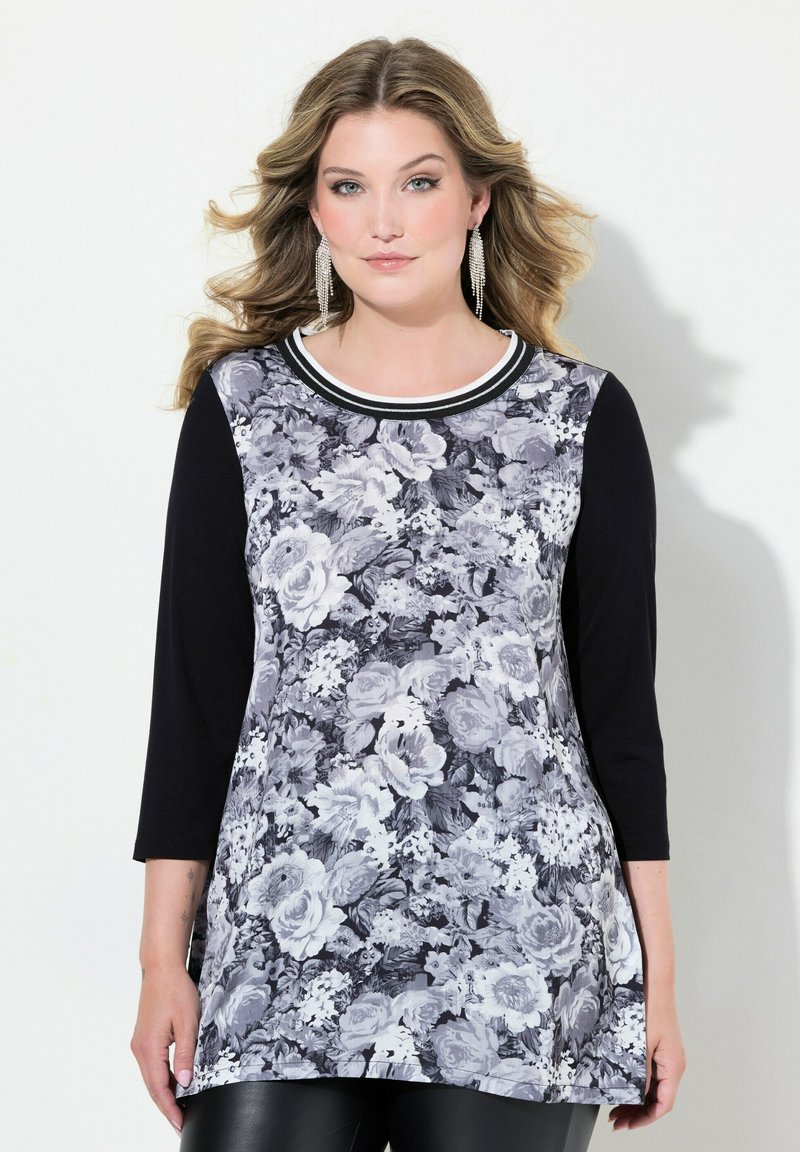 Blumenmuster Langarm-Tunika in Schwarz und Weiß, mit einem runden Ausschnitt und kontrastierender Borte sowie einem fließenden Design mit Blumenmustern.