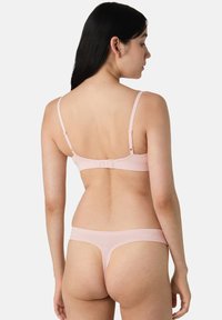 Set di lingerie rosa chiaro composto da un reggiseno con spalline regolabili e chiusura posteriore a gancio, abbinato a un perizoma coordinato.