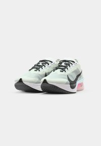 Light green running shoes with a textured upper, black Swoosh, black laces, and a multicolored sole (blue and pink). Rubber outsole for traction.