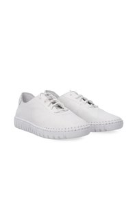 White lace-up shoes with a perforated leather upper, textured design, and a thick, flexible white rubber sole with stitching details.