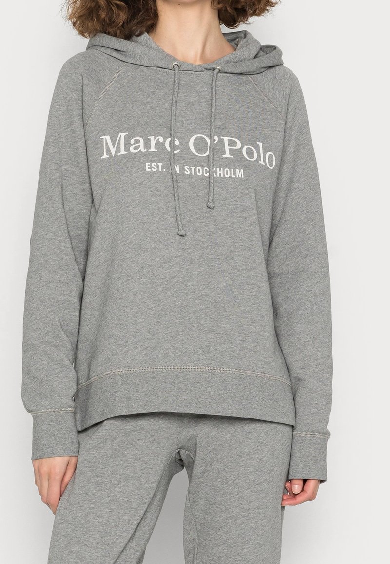 Sudadera gris hecha de material suave, con capucha ajustable, puños acanalados y un logo blanco impreso en el pecho.
