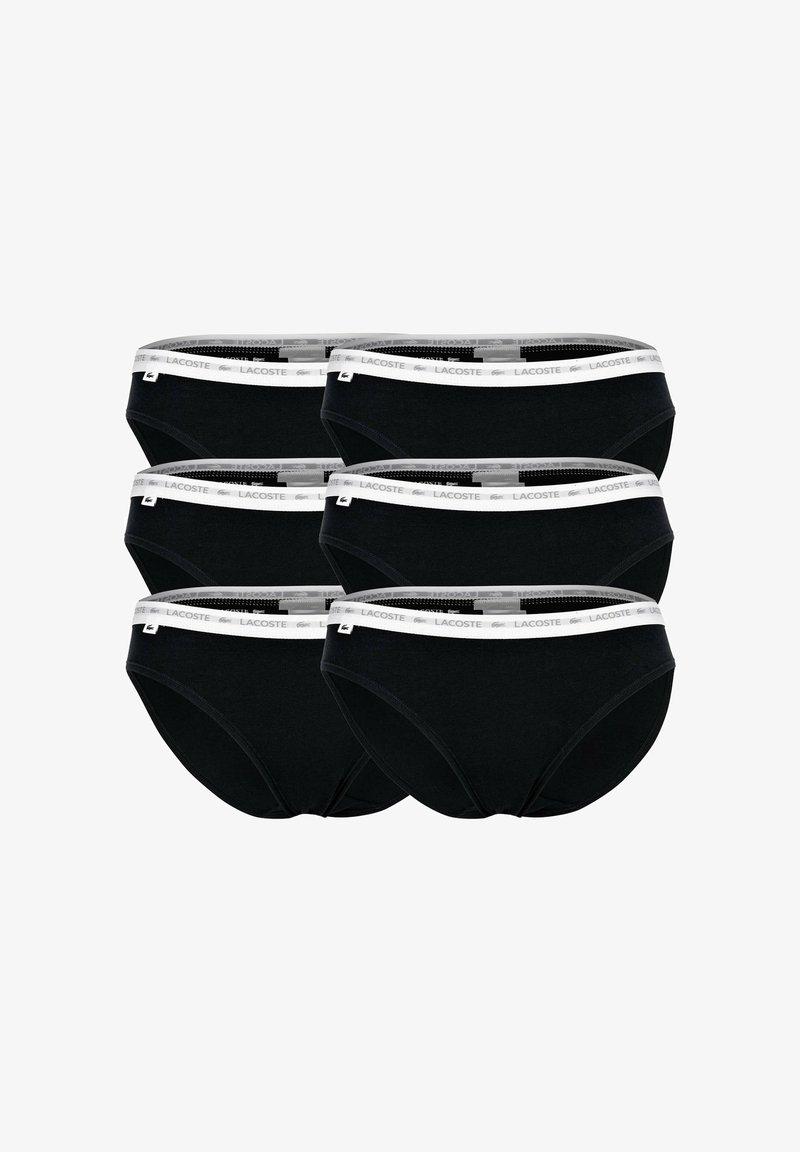 Slip in cotone neri con una vita elastica bianca che presenta il logo Lacoste. Sei paia esposte in una pila.