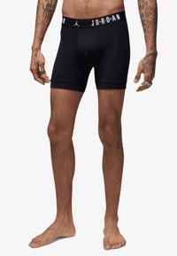 Juodos bokso trumpikės su „Jordan“ logotipu ant elastinio diržo. Pagamintos iš lygaus audinio, skirtos patogumui ir prigludusiai formai.