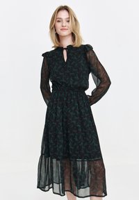 Black dress with long sheer sleeves, frill collar, and a keyhole neckline. Features a floral pattern in green and red, with a tiered skirt.