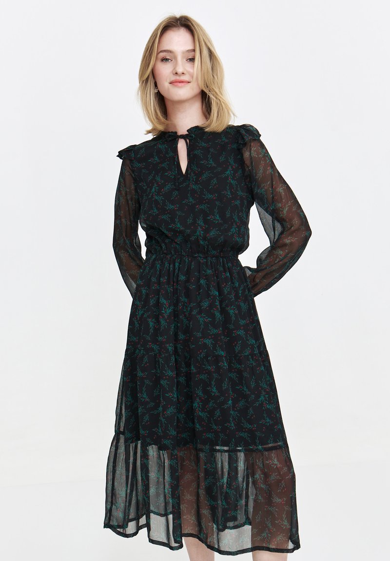 Black dress with long sheer sleeves, frill collar, and a keyhole neckline. Features a floral pattern in green and red, with a tiered skirt.