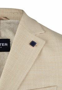 Beiger, strukturierter Blazer mit feiner Webart, versehen mit einem schwarzen Reverspin und gemustertem Innenfutter. Enthält ein "H"-Logo auf dem Etikett.