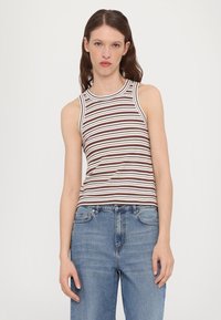 Stripet tanktopp i brun og hvit med en ribbet tekstur, med rund hals og uten ermer, satt sammen med lyseblå jeans.