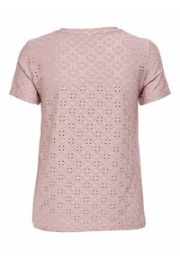 T-shirt rosa a maniche corte con un motivo testurizzato e ritagli, scollatura rotonda e vestibilità ampia. Tessuto morbido, lunghezza circa a metà.